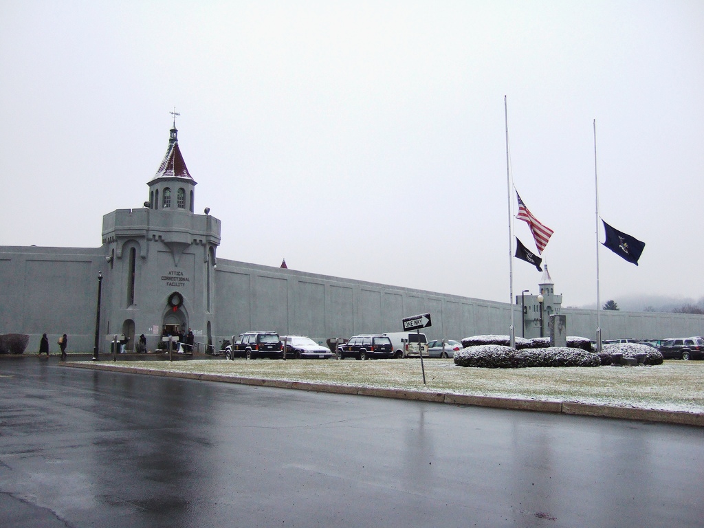 Entrance to Attica Correctional Facility with flags at half-mamst in foreground